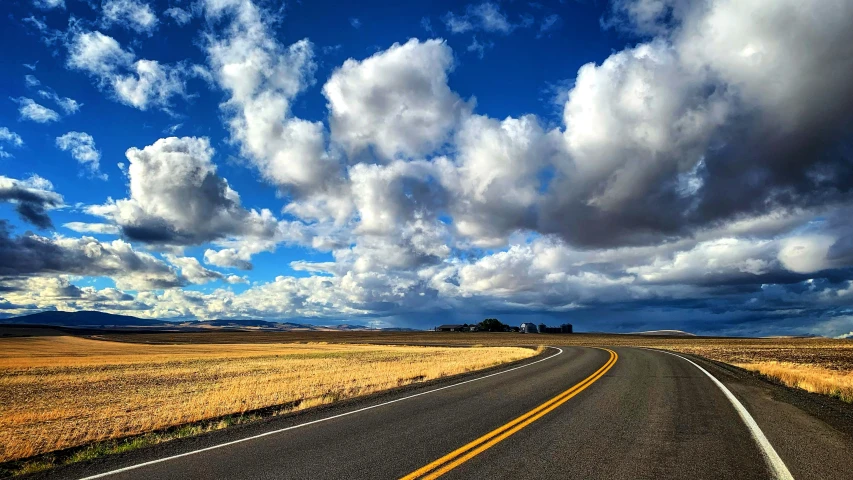 an empty road is shown on the plains