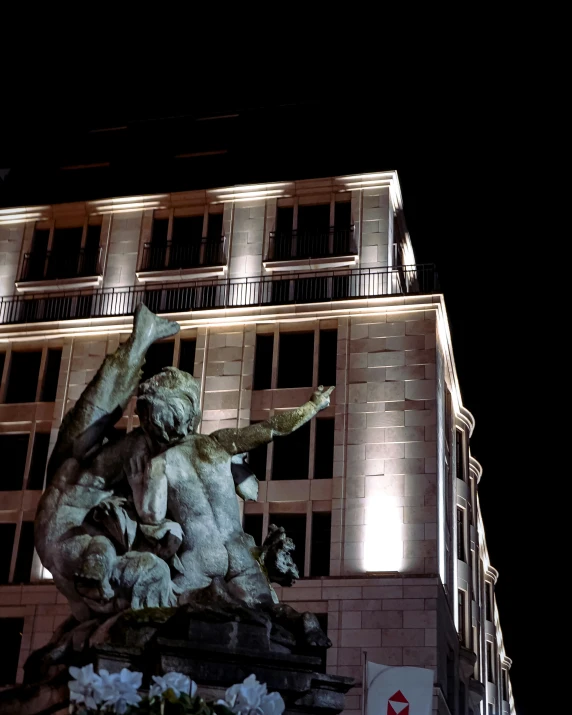 a statue in front of a building with a clock tower