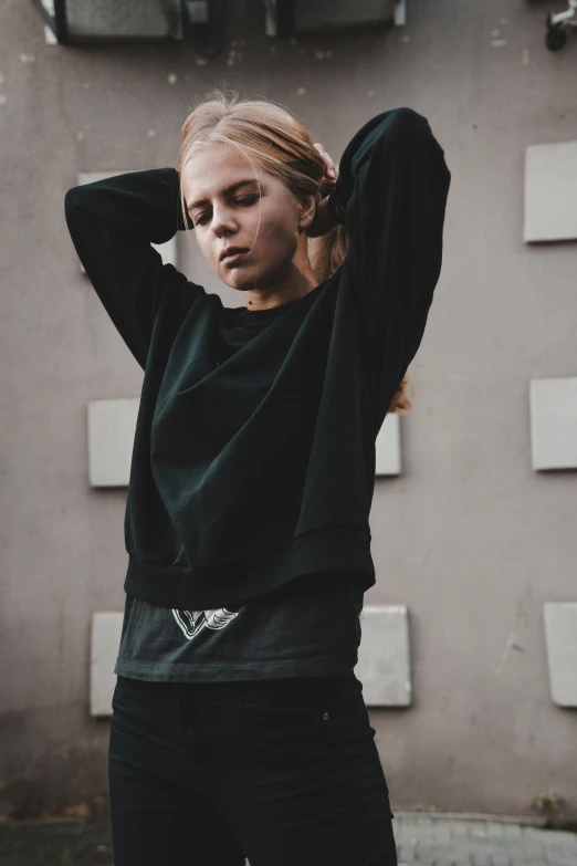 a woman standing with her hand on her head