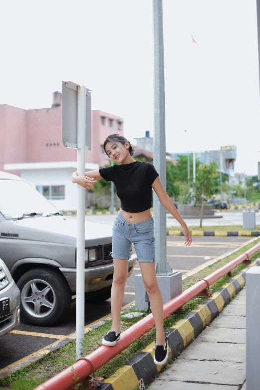 a woman standing on a pole leaning against the side