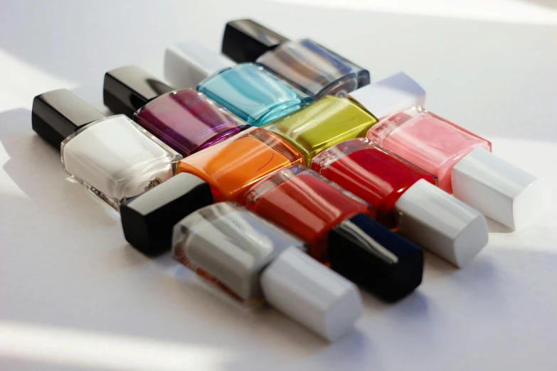 colorful nail polish lined up on a white table