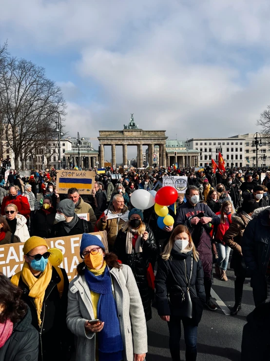 many people gather on the street holding banners