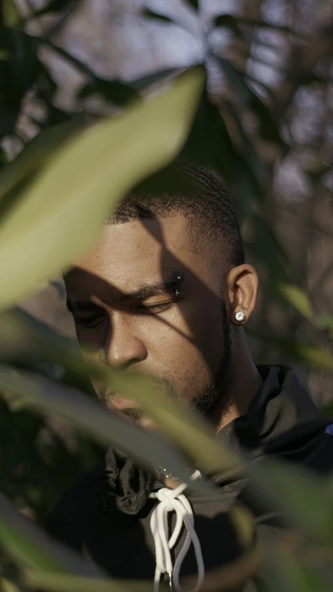 a man with earrings looking into a jungle