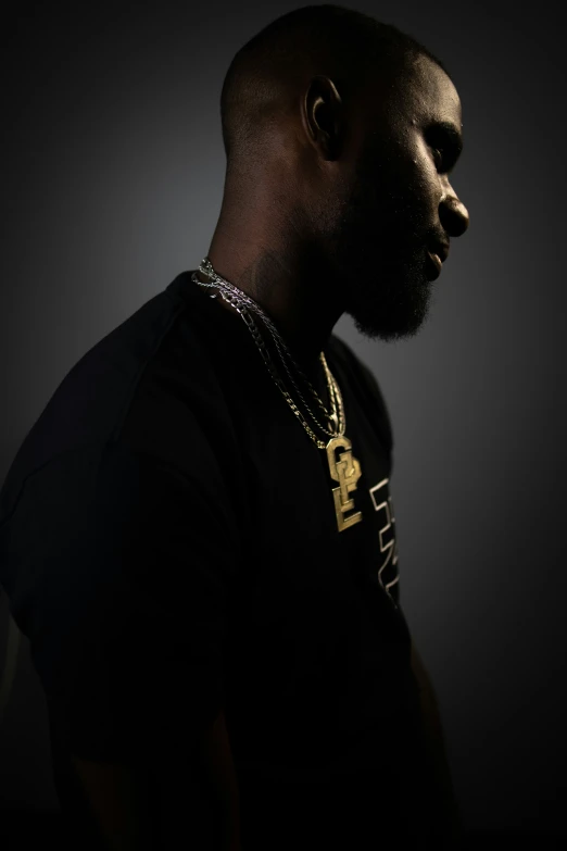 man in black shirt with gold necklace and necklace