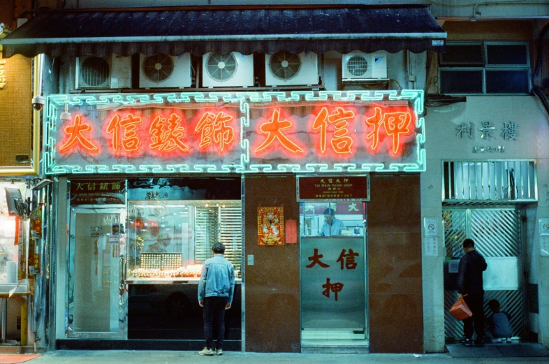 a couple of people that are standing outside of a restaurant