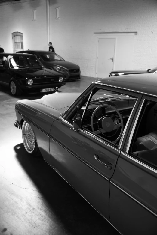 two cars are parked in an empty garage