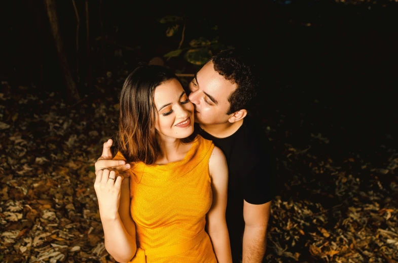 a woman is hugging a man with her hand around his face