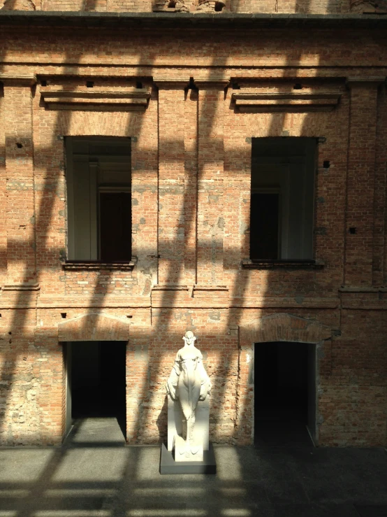 shadows cast on a brick building over a fire hydrant