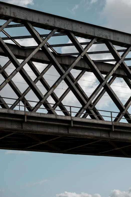 a black bird sits on the railing of a bridge