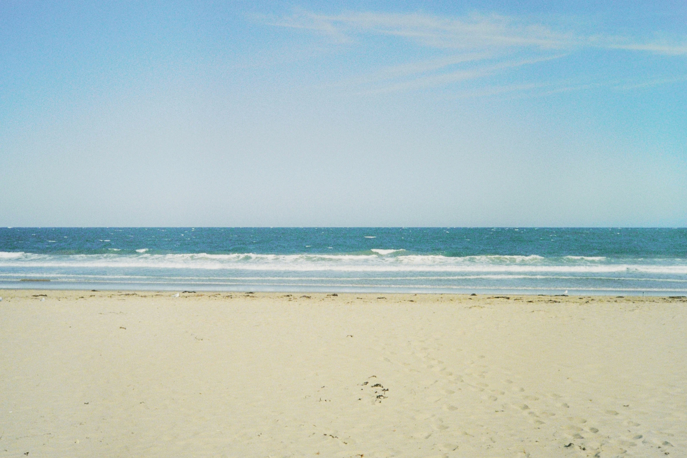 a person walking on the beach looking out at the ocean