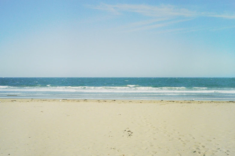 a person walking on the beach looking out at the ocean