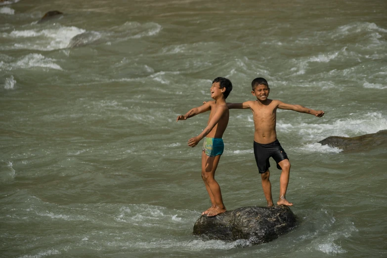 two s standing on a rock in the river