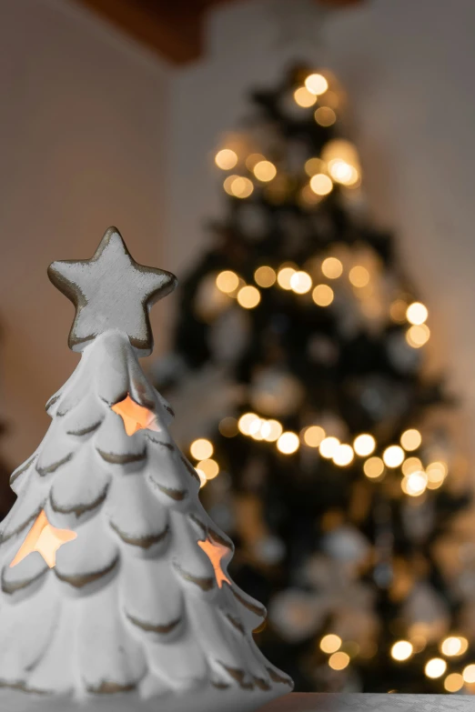 a white christmas tree sitting in front of a fake christmas tree