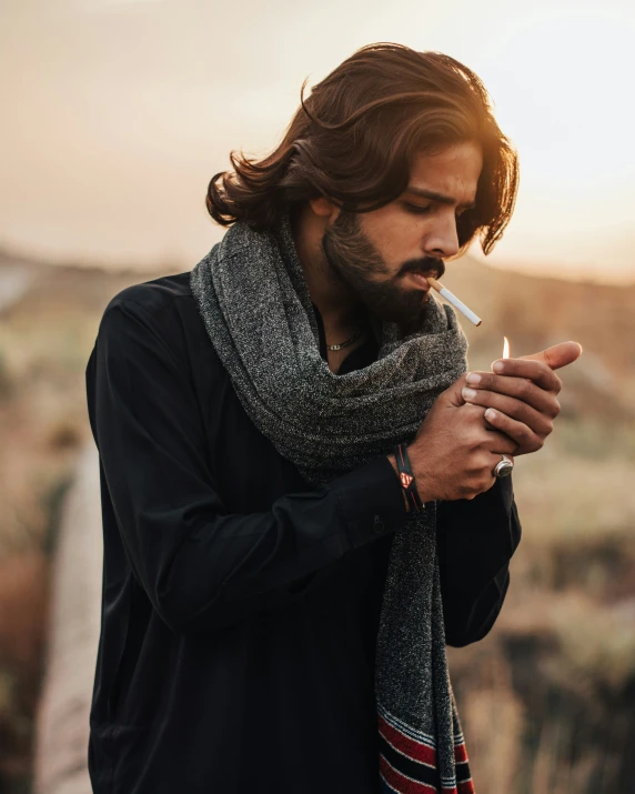 man with beard holding cigarette and sweater on holding a cigarette