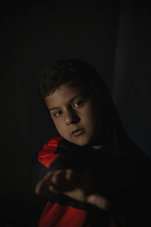 a young child with a hooded sweatshirt on holding up their hand