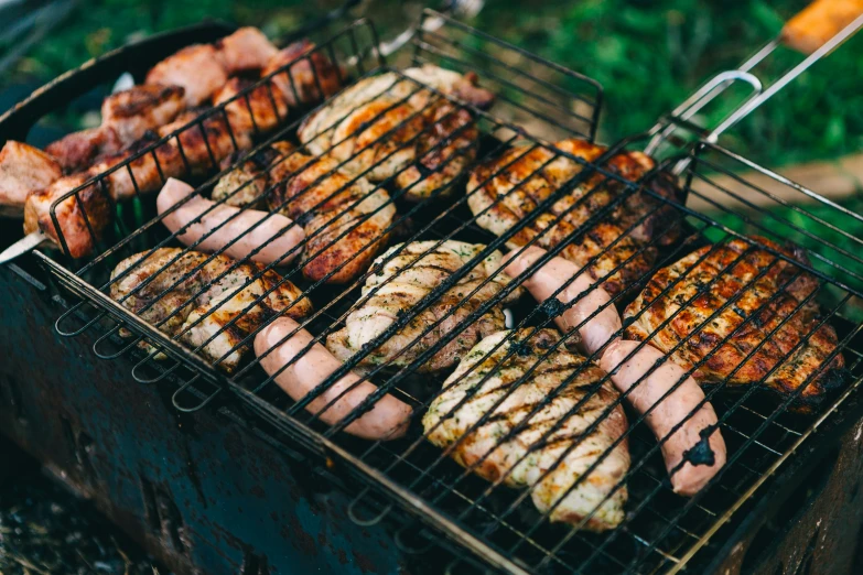 chicken and sausage cooking on a bbq grill