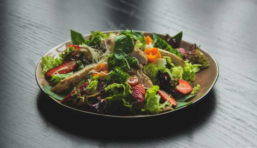 there is a plate of salad on a table