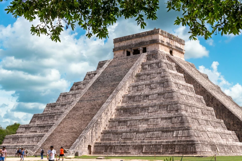 people standing in front of a tall pyramid