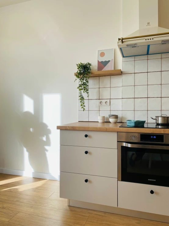 a clean, white kitchen with cabinets and wooden floors