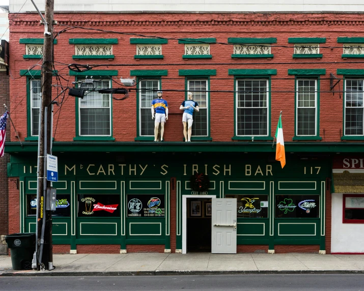 a green and red building with two people hanging out