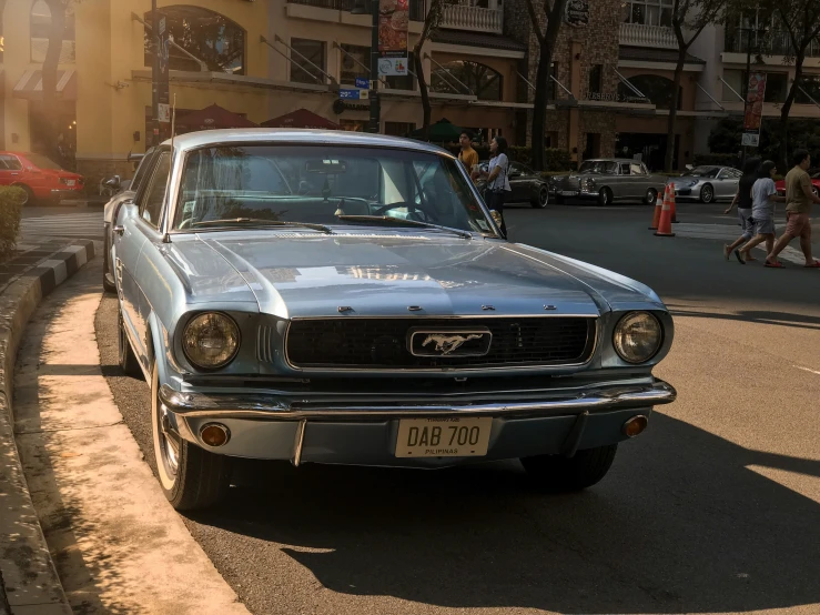 a gray mustang is parked on the street