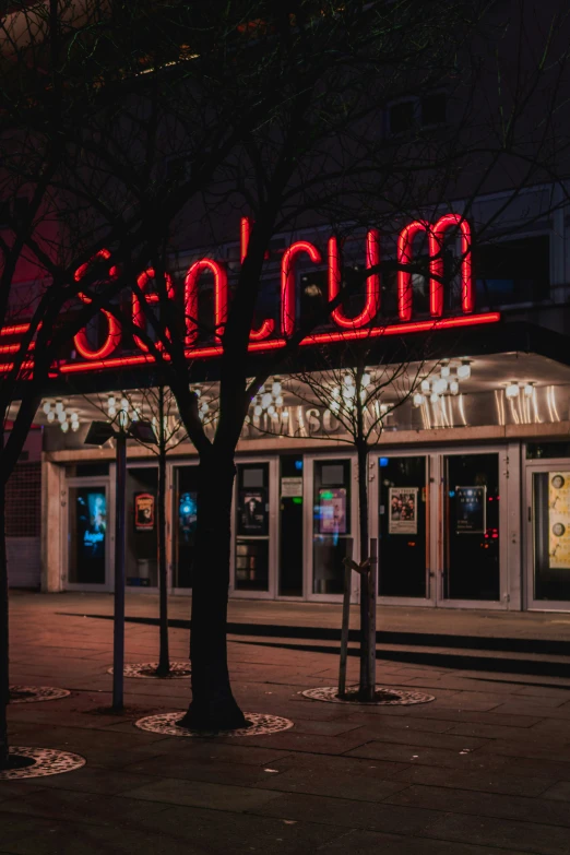 a lit up business at night on a sidewalk