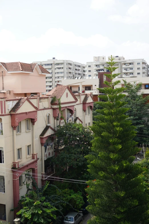 a large building with red roofing surrounded by trees and buildings