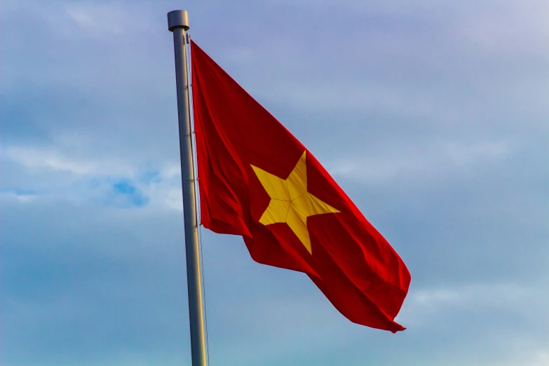 a large flag flying high up on top of a flag pole