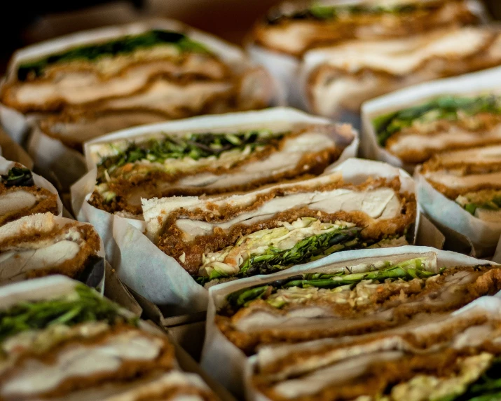 a group of sandwiches sitting on top of paper wrappers