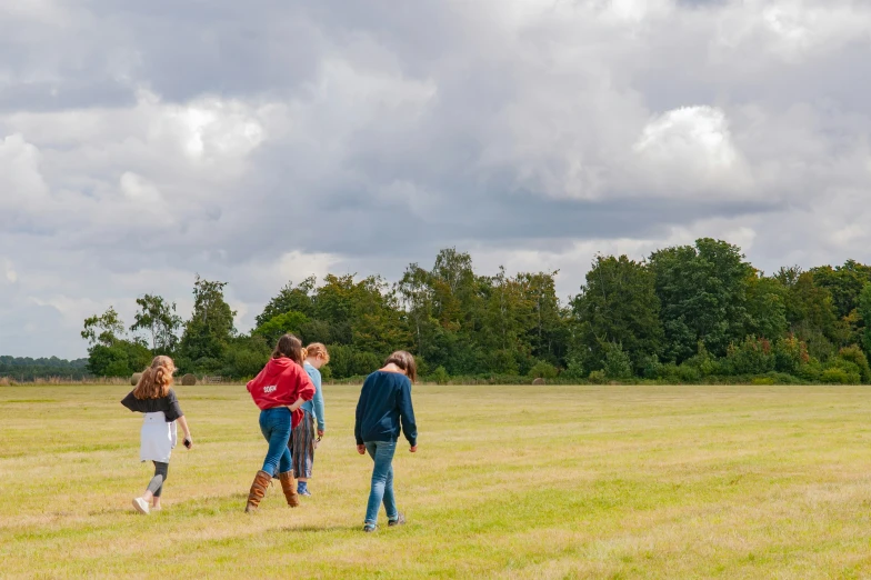 people are standing in a field near a plane