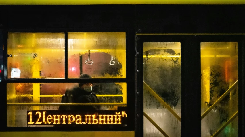 a yellow bus at night with it's lights on