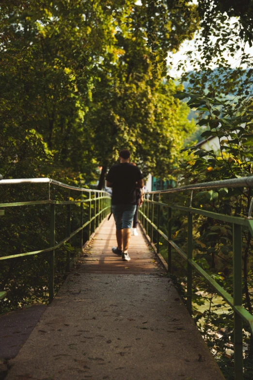 a couple of people that are walking across a bridge