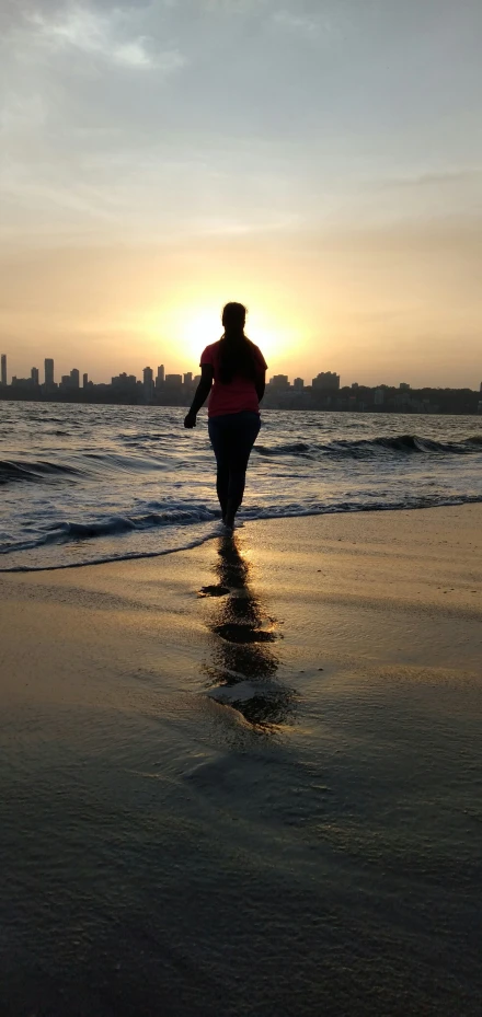 a person is walking on a beach near the ocean