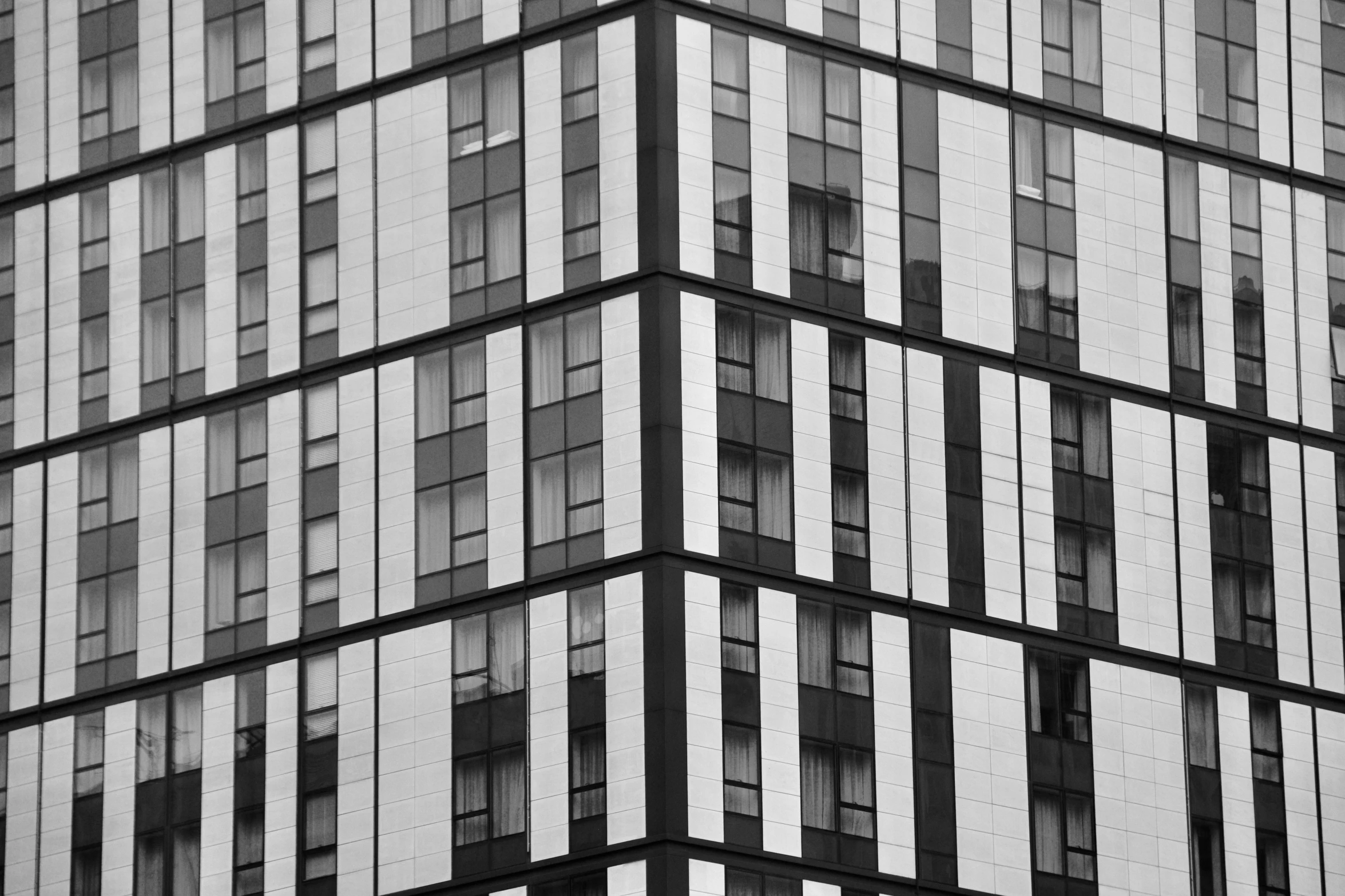 a large glass building in the city has many windows