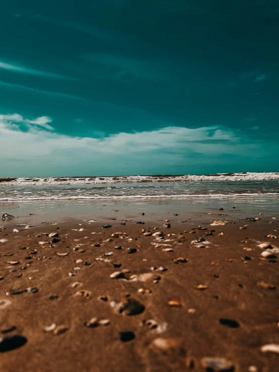 rocks are on the shore line as an airplane comes in