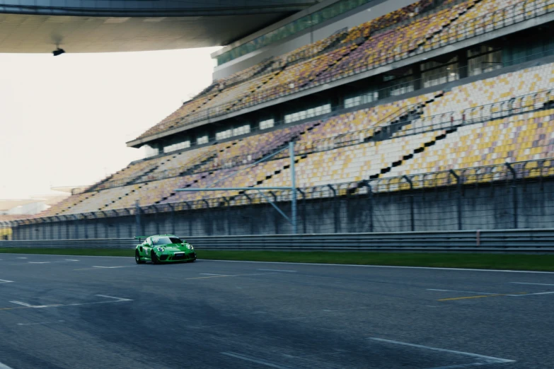 a green race car driving on the track