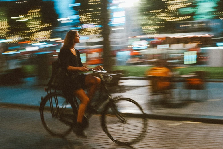 there is a woman riding a bicycle down the street