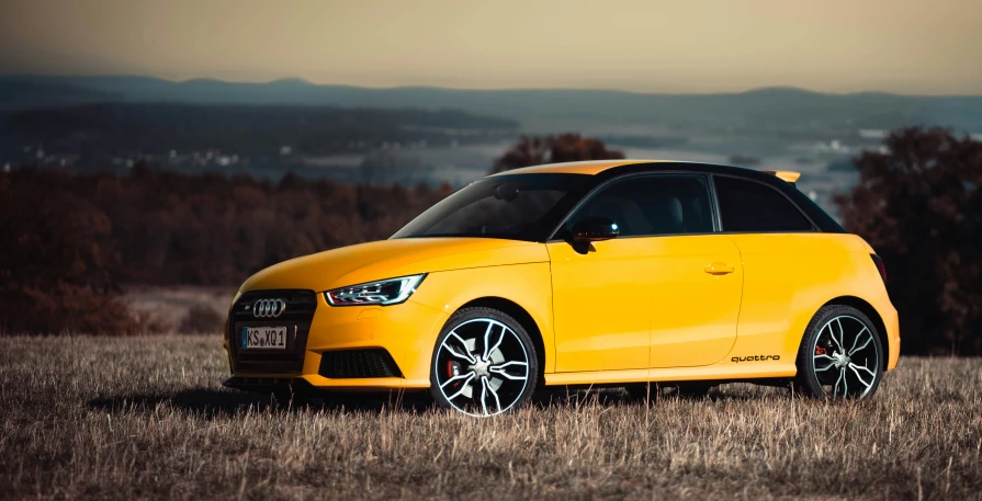 the yellow car is parked in a field with brown grass