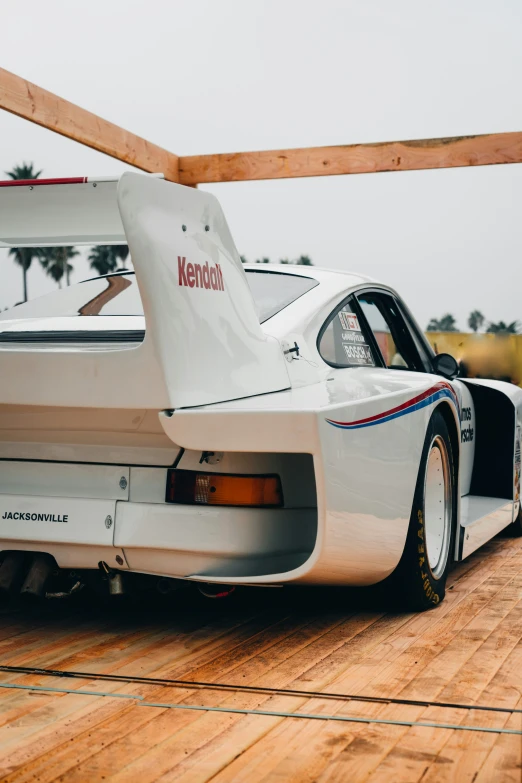 an old race car sits parked in a lot