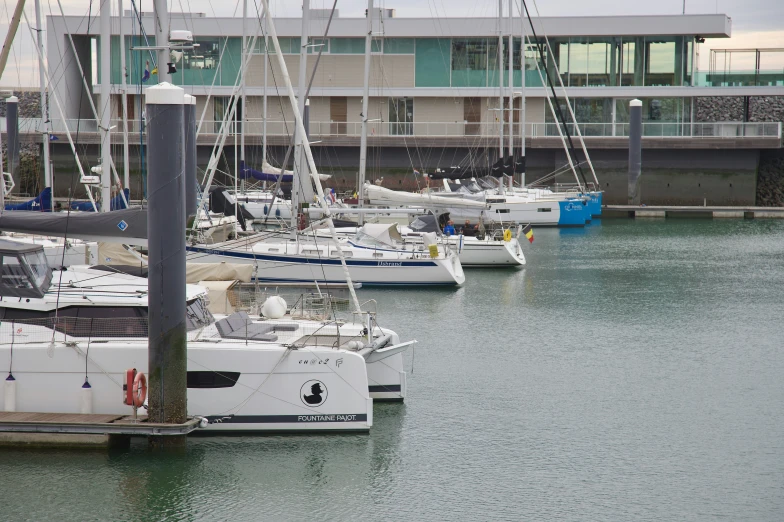 a row of small sailboats are parked by a dock