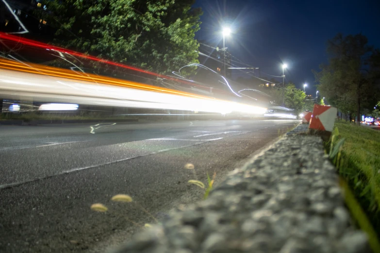 blurry image of an intersection at night with cars speeding down the road