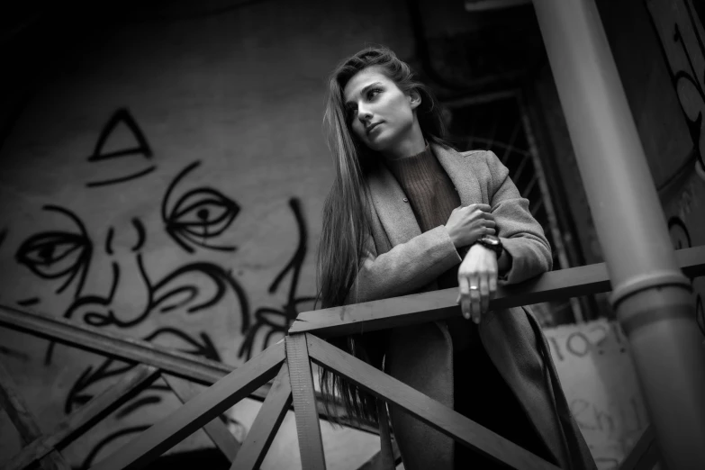 a woman with long hair stands next to a railing