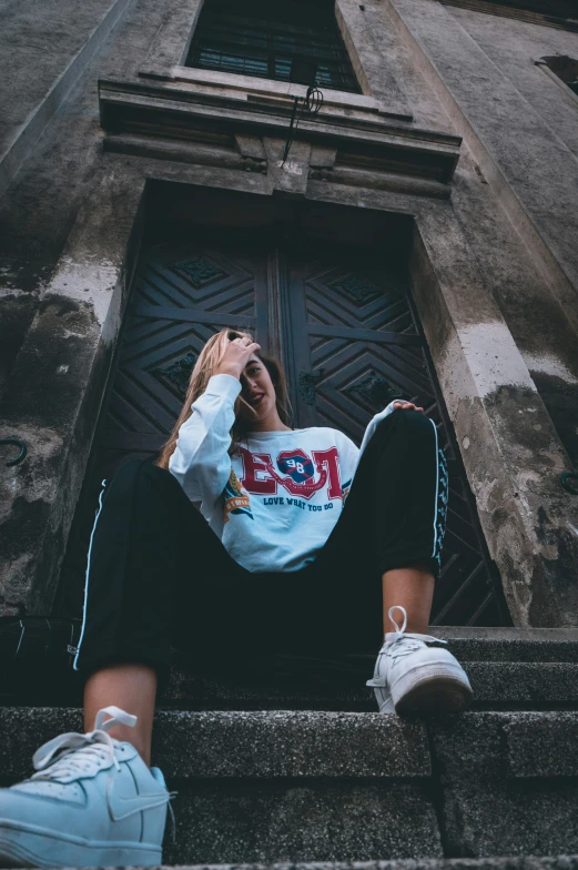 a man is sitting down outside wearing sneakers