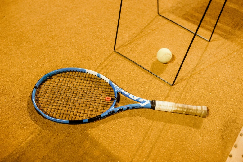 a blue tennis racket resting on the ground