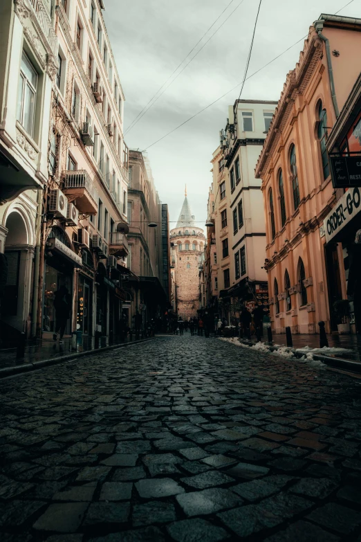 a city street with brick pavement and tall buildings