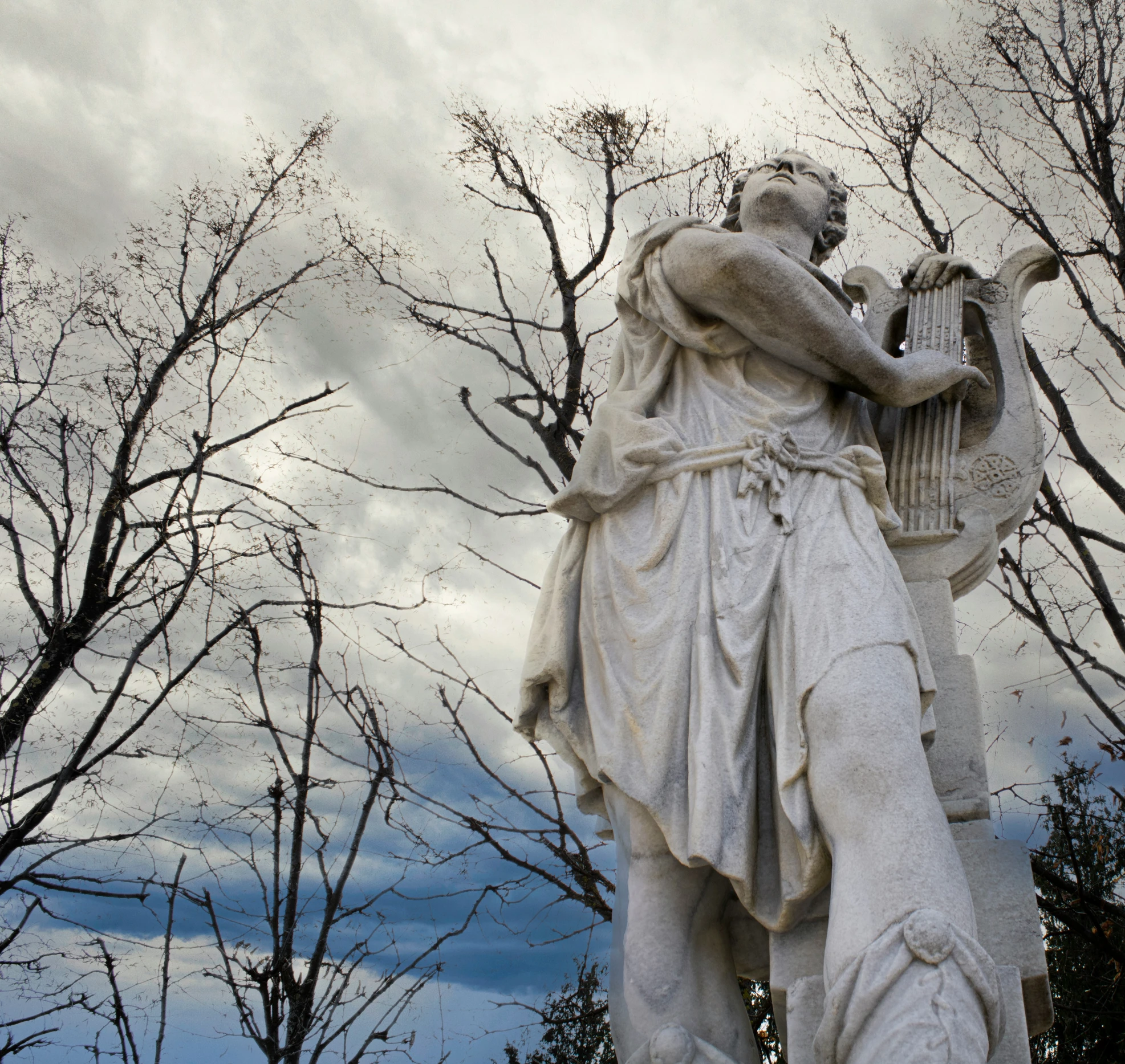 there is a statue on a stand in the woods