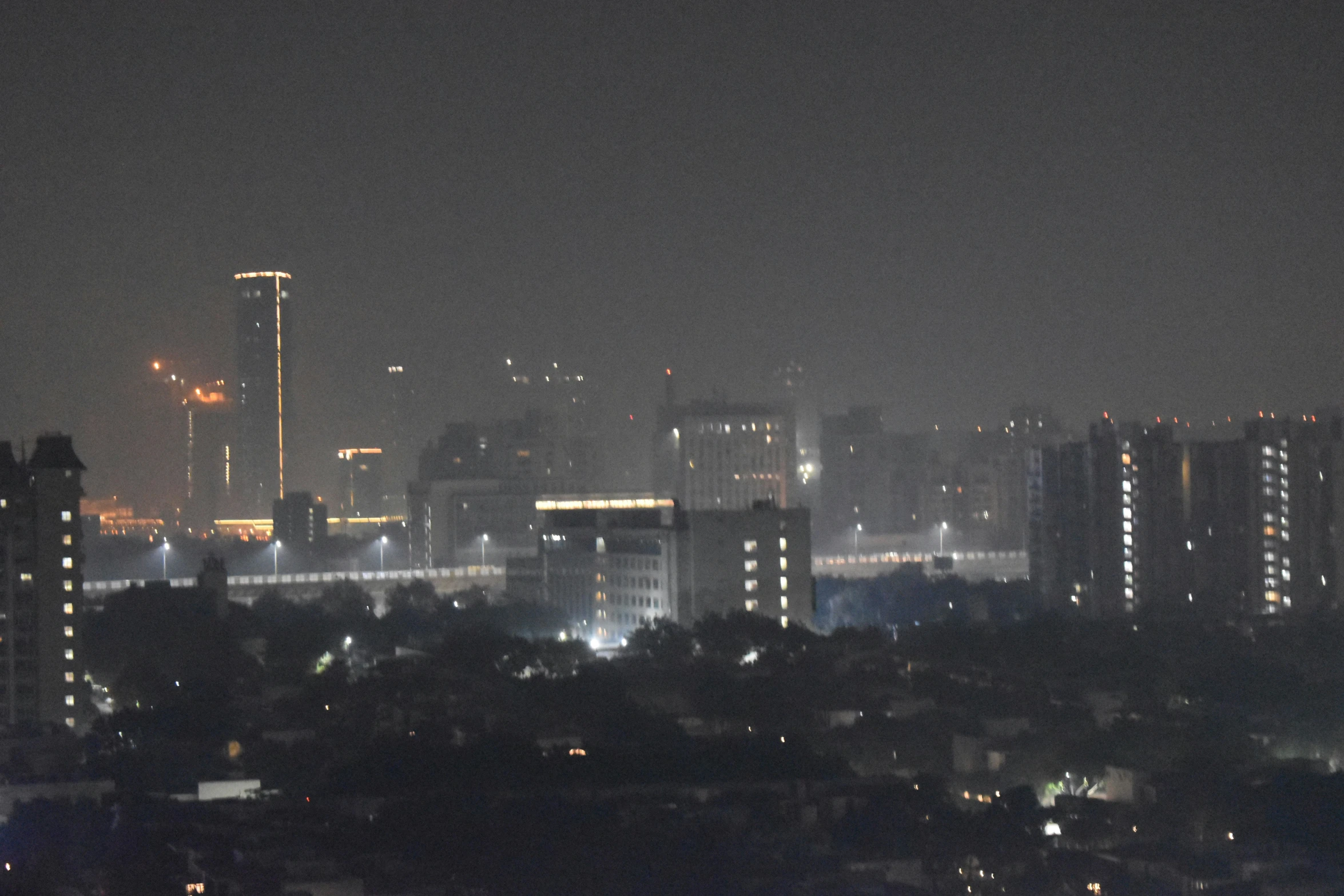 dark city skyline with skyline lights and trees