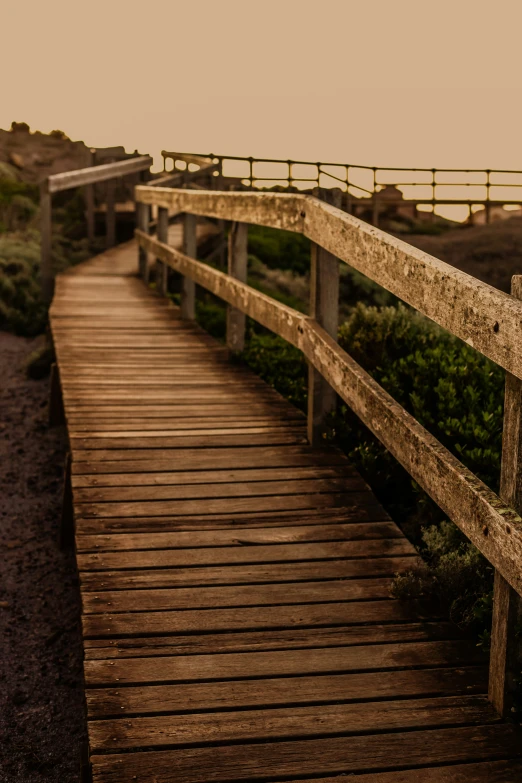 a wooden walkway in the desert during the day