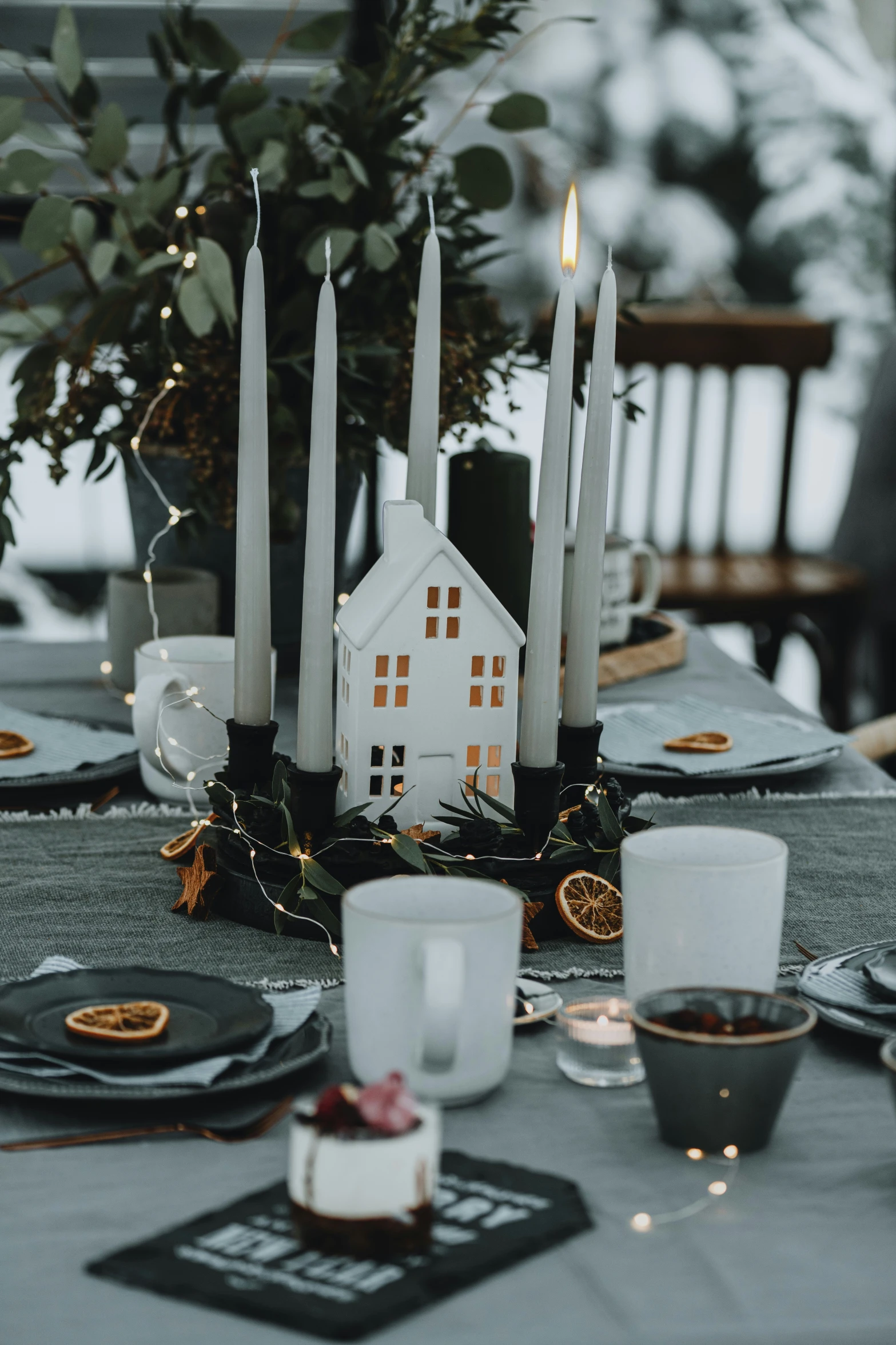 a table with a plate of cake, candles, and some plates