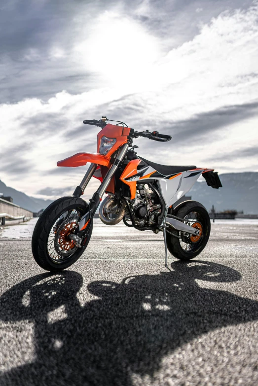 a dirt bike parked on the concrete in front of a fence